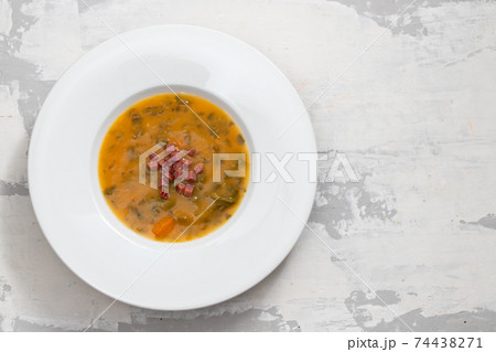 soup with smoked meat in white plate on ceramic dish 74438271