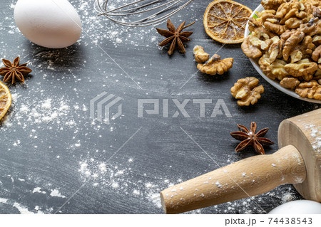 Bakery food. Fresh food ingredients: flour, eggs, nut and star anise, orange on black chalkboard background for bread. Cooking flat lay with copy space. Top view. Baking concept. 74438543
