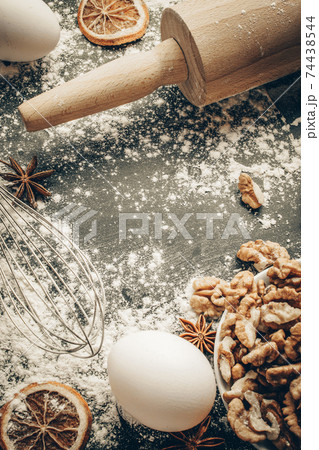 Bakery flat design. Cooking food ingredients: flour, eggs, nut and star anise, orange on dark table kitchen background for cake. Top view with copy space for text, recipe, menu. 74438544