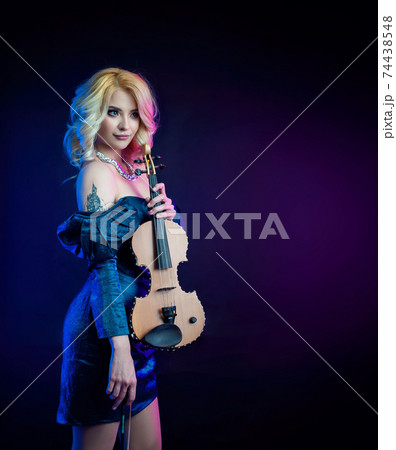 portrait of a blonde woman playing a violin in neon light 74438548