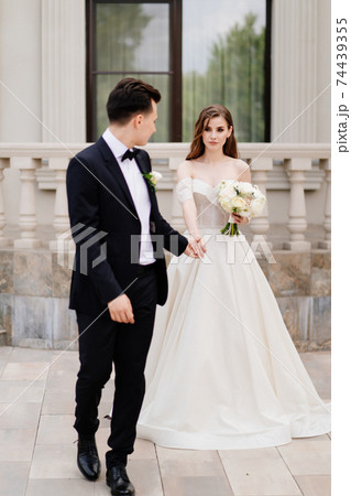 The groom and the bride walk outdoors. first meeting before the wedding ceremony The groom and the bride walk outdoors. first meeting before the wedding ceremony 74439355