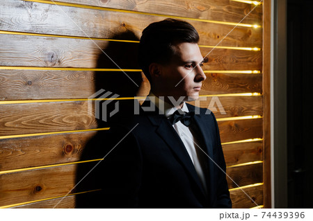 young man in white shirt and a black jacket and a bow tie young man in white shirt and a black jacket and a bow tie 74439396