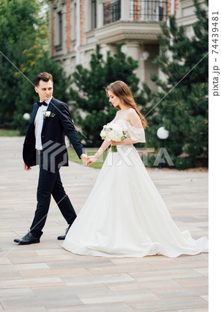 The groom and the bride walk outdoors. first meeting before the wedding ceremony The groom and the bride walk outdoors. first meeting before the wedding ceremony 74439481