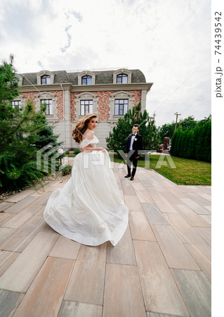 The groom and the bride walk outdoors. first meeting before the wedding ceremony The groom and the bride walk outdoors. first meeting before the wedding ceremony 74439542