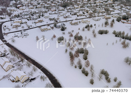 Aerial view of snowed in traditional housing estate the suburbs in dangerous weather conditions Aerial view of snowed in traditional housing estate the suburbs in dangerous weather conditions 74440370