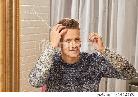 Man smiling and checking hair. 74442430
