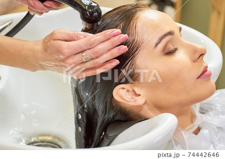 Woman getting her head washed. 74442646