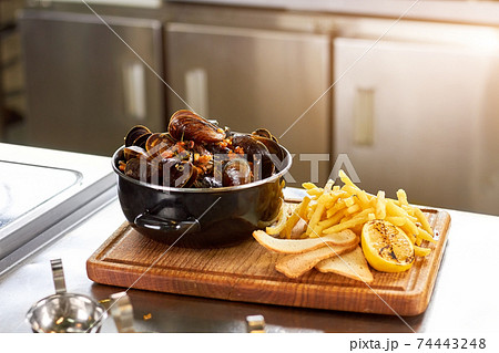 Dish with mussels and french fries. Dish with mussels and french fries. 74443248
