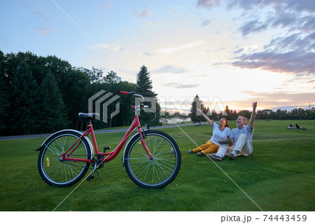 Happy mature couple sits on the lawn. 74443459
