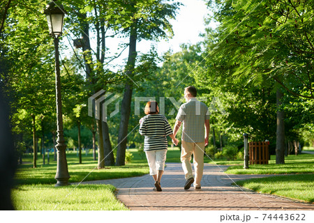 Couple holding hands in the park. Couple holding hands in the park. 74443622