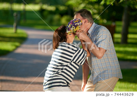 Kissing mature couple outdoors. 74443629