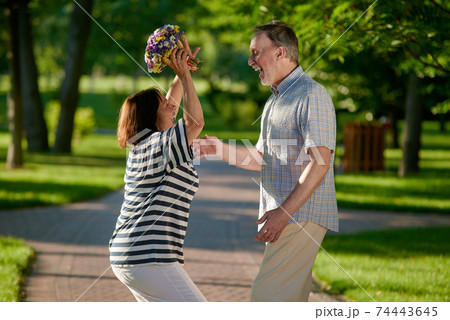 Happy wife and husband with bouquet of flowers. 74443645