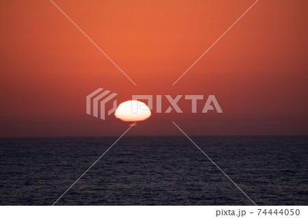 水平線に沈む変形した夕陽 74444050