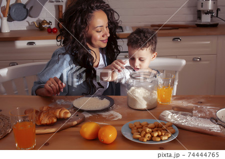 young pretty african american mother with little cute son on kitchen in morning preparing breakfast, lifestyle people concept young pretty african american mother with little cute son on kitchen in morning preparing breakfast, lifestyle people concept 74444765