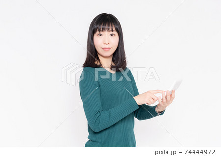 白背景の前に立って電卓を使う女性 白背景の前に立って電卓を使う女性 74444972
