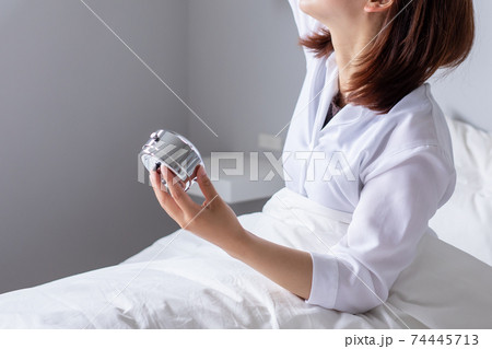 朝起きると頭やお腹が痛い若い代の女性の写真素材