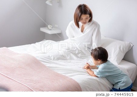 ベットで母親と子供が話をしている 74445915