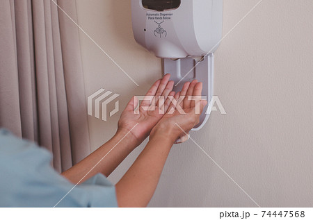 Patient woman using automatic alcohol dispenser sanitation for cleaning hands in hospital,Protection spread of coronavirus Patient woman using automatic alcohol dispenser sanitation for cleaning hands in hospital,Protection spread of coronavirus 74447568