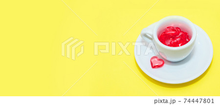 cup with hearts on a red background. the view from the top. red hearts spilled out. isolated on a pink background. copy space. panton 74447801