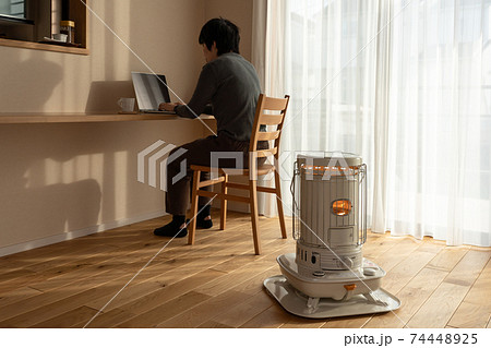 カウンターテーブルでパソコン作業する女性 ストーブ (冬) カウンターテーブルでパソコン作業する女性 ストーブ (冬) 74448925