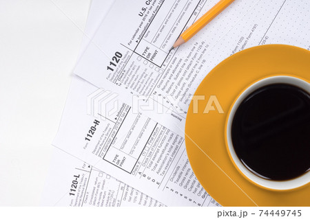 1120 tax forms top view with coffee cup and pencil 1120 tax forms top view with coffee cup and pencil 74449745