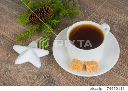 coffee cup with xmas tree branch and star bauble on rustic woode 74450111