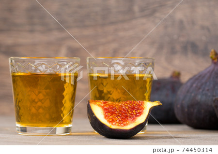 figs liqueur and fresh fruits on rustic table 74450314