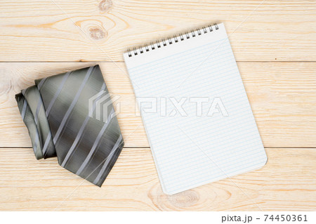 gray neck tie with empty paper sheet on workbench gray neck tie with empty paper sheet on workbench 74450361