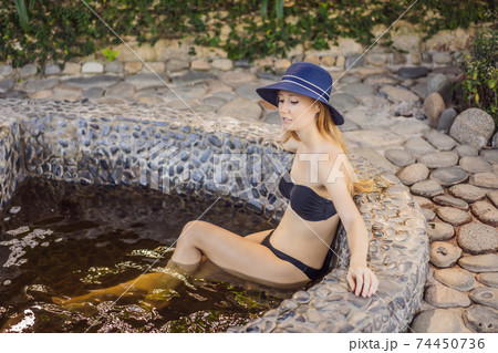 Woman relaxing in round outdoor fragrant herbal bath, organic skin care, luxury spa hotel, lifestyle photo Woman relaxing in round outdoor fragrant herbal bath, organic skin care, luxury spa hotel, lifestyle photo 74450736