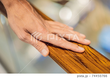 support, help and people concept - close up of man hand holding to railing support, help and people concept - close up of man hand holding to railing 74450766