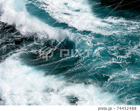 飛沫を上げながら打ち寄せる波のアップの写真素材