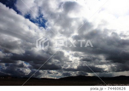 雲の群れの隙間にわずかな青空の風景の写真素材