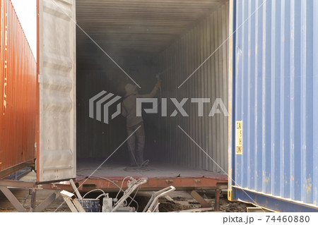 Industrial worker spray to clean inside container storage logistic shipping freight business manufacturing. Warehouse store. 74460880