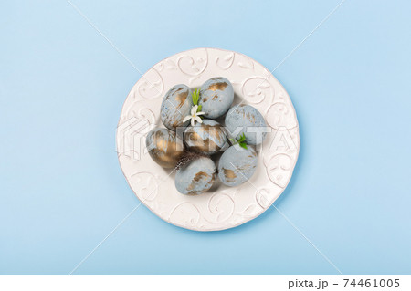 Easter Decoration with blue golden eggs, quail feathers, flowers on blue background. Happy Easter card concept. 74461005