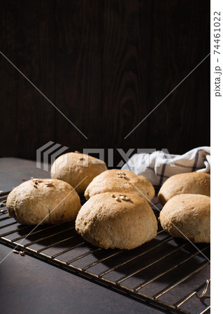 Homemade wholemeal rye wheat buns with seeds on wooden table, dark rustic background. 74461022