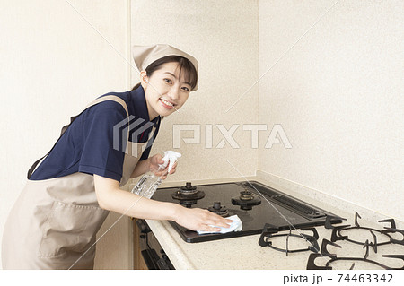 ガスレンジの清掃をするハウスクリーニングの女性作業員 74463342