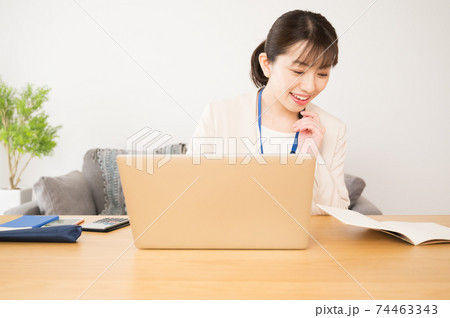 ノートパソコンでテレワーク中の女性 ノートパソコンでテレワーク中の女性 74463343