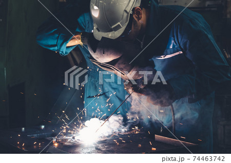 Skillful metal worker working with arc welding machine in factory Skillful metal worker working with arc welding machine in factory 74463742