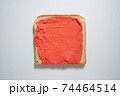 spreading red paste on a toast on white Background. Top view 74464514