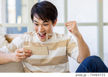 動画をスマホで見る男性 74464725