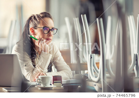 Bar owner sits indoors thinking over unstable future of the business over a cup of coffee 74465796