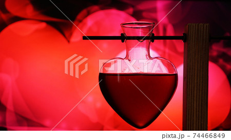 Open heart-shaped bottle of red love potion on a blurred background 74466849