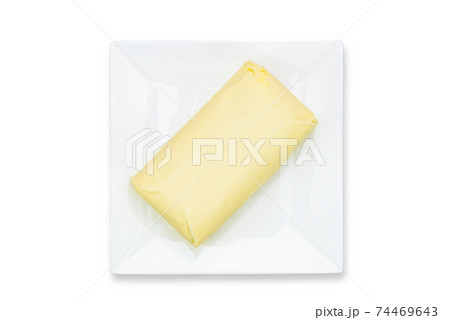 Top view of fresh organic butter block on the plate isolated on a white background in close-up. PNG file with transparent background. 74469643