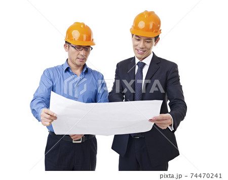 asian businessmen with safety helmet and blueprint, isolated on white background asian businessmen with safety helmet and blueprint, isolated on white background 74470241