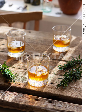 Scotch or bourbon with ice on a wooden background 74470721