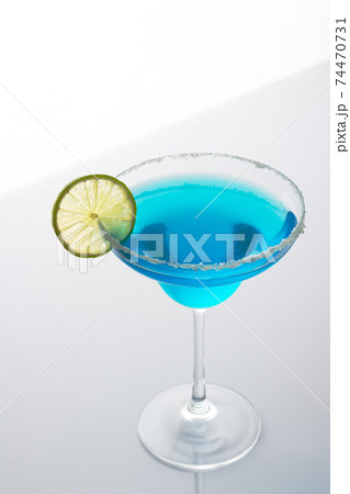 Blue alcoholic drink in glass with lime slice 74470731