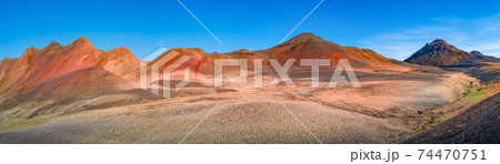 Panoramic view over volcanically active zone in Highlands of Iceland, resembling Martian red planet landscape, with black volcano and red slopes, at summer and blue sky. Panoramic view over volcanically active zone in Highlands of Iceland, resembling Martian red planet landscape, with black volcano and red slopes, at summer and blue sky. 74470751