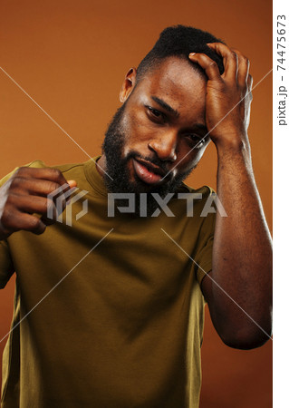 young pretty african american man posing cheerful on brown background, lifestyle people concept young pretty african american man posing cheerful on brown background, lifestyle people concept 74475673