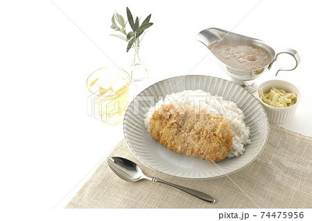 豚カツが乗った熱々ご飯とルーが入ったカレーポットとトッピングのナチュラルチーズとお茶とオリーブの葉 豚カツが乗った熱々ご飯とルーが入ったカレーポットとトッピングのナチュラルチーズとお茶とオリーブの葉 74475956