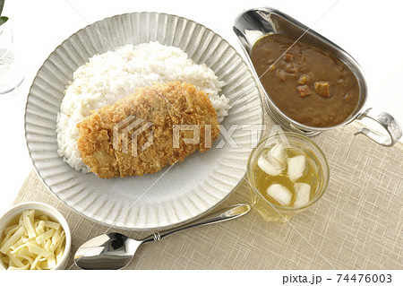 豚カツが乗った熱々ご飯とルーが入ったカレーポットとトッピングのチーズとお茶とオリーブの葉（俯瞰） 74476003